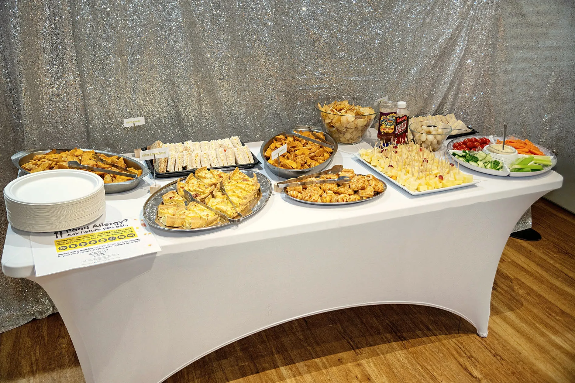 Buffet laid out in front of a sequin backdrop