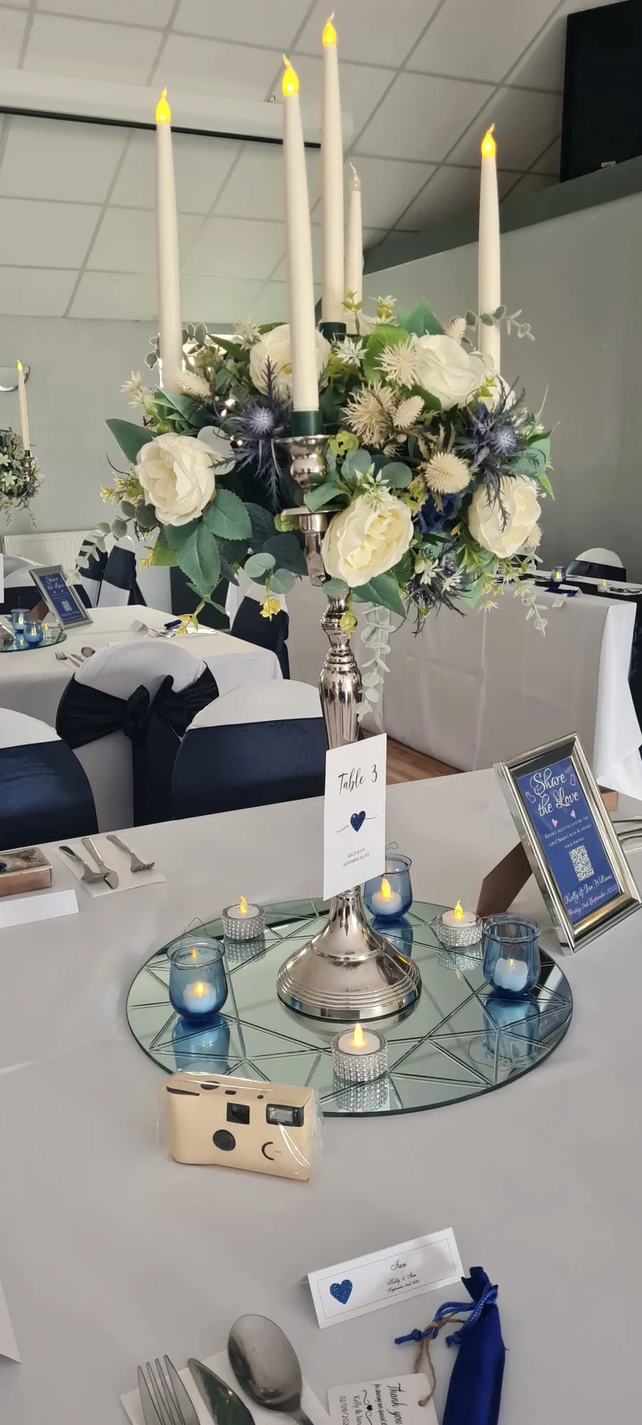 Candelabra centrepiece with ivory roses on a navy-themed table