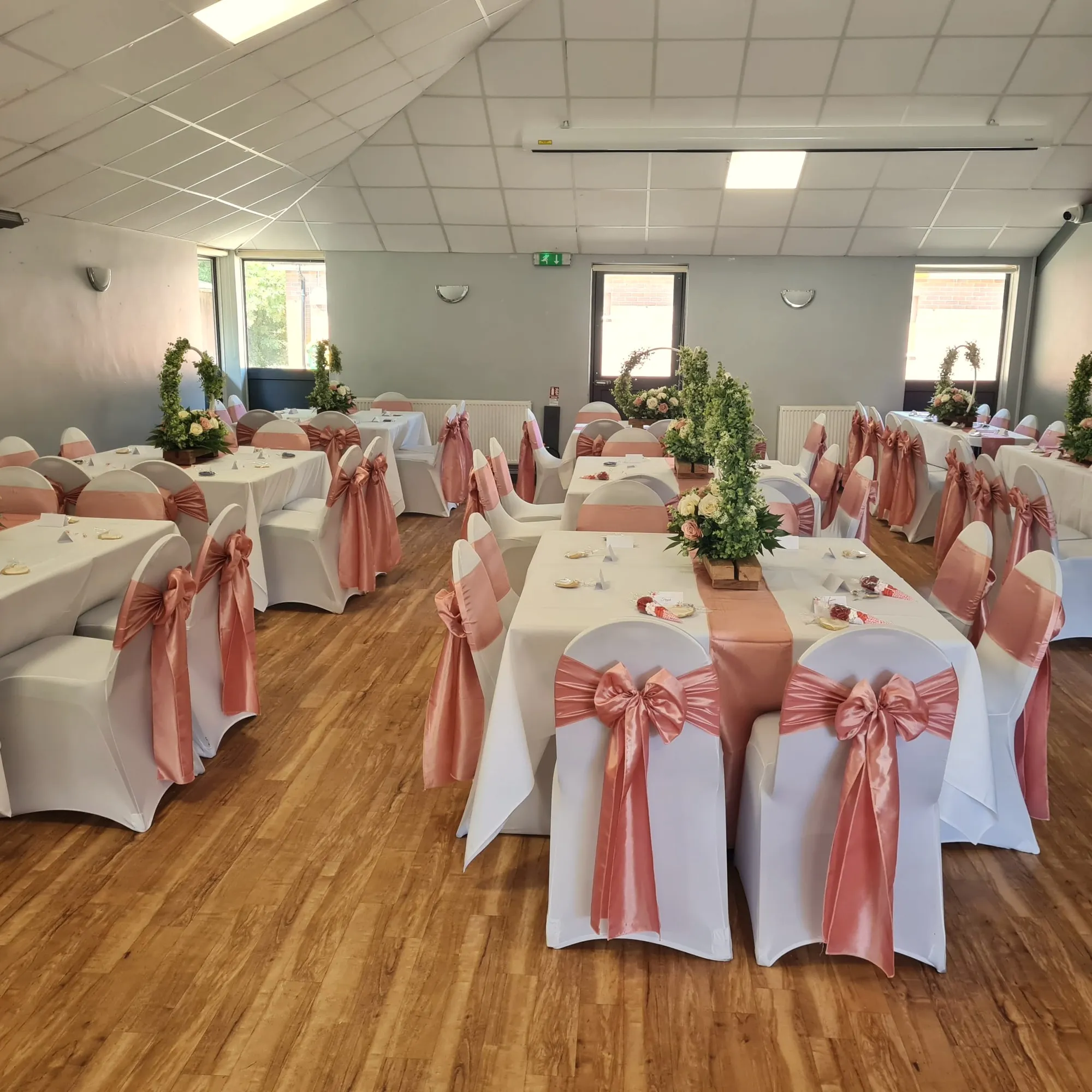 Long tables dressed with coral sashes