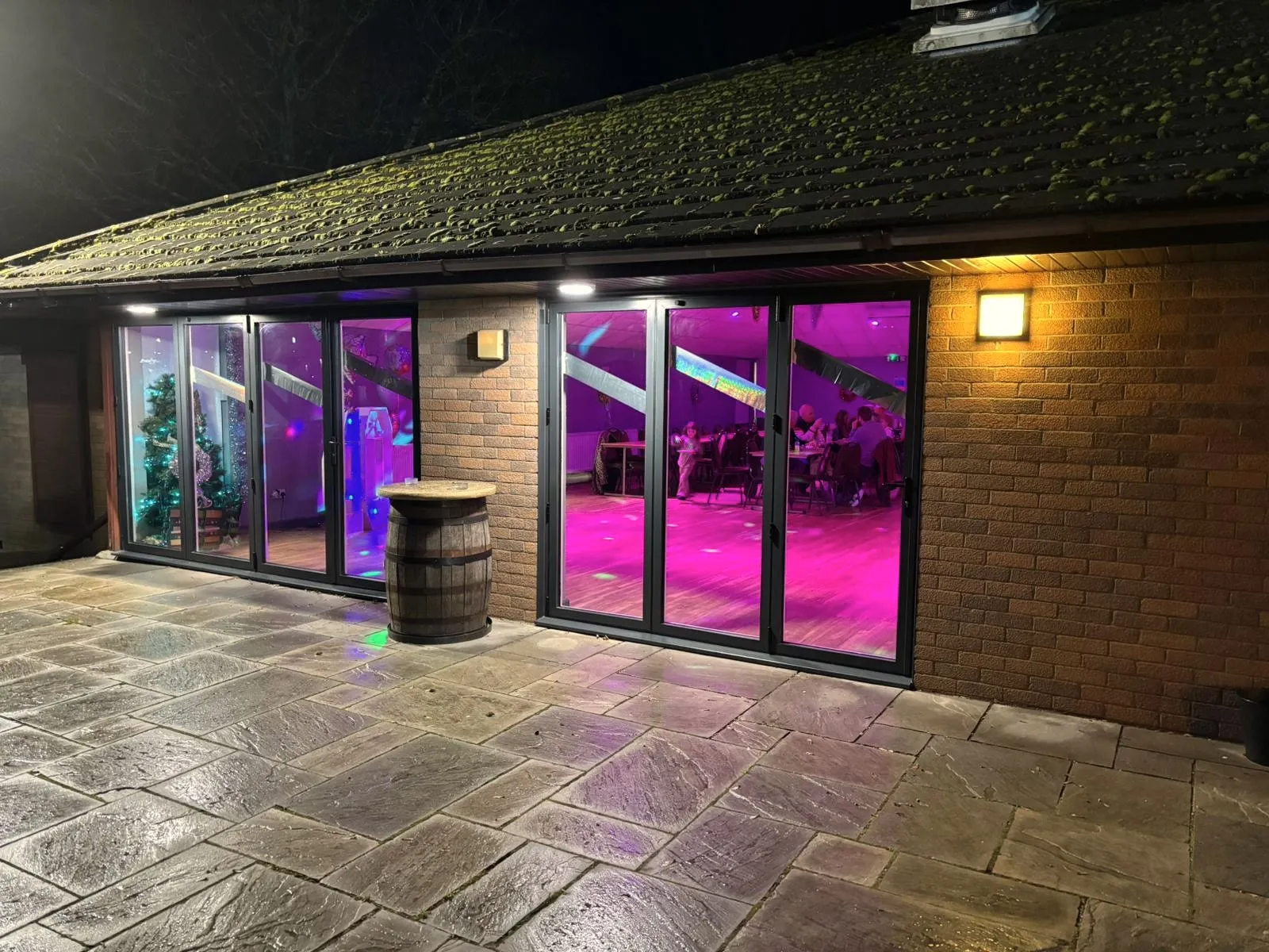 The venue at night, its bifold doors glowing with party lights