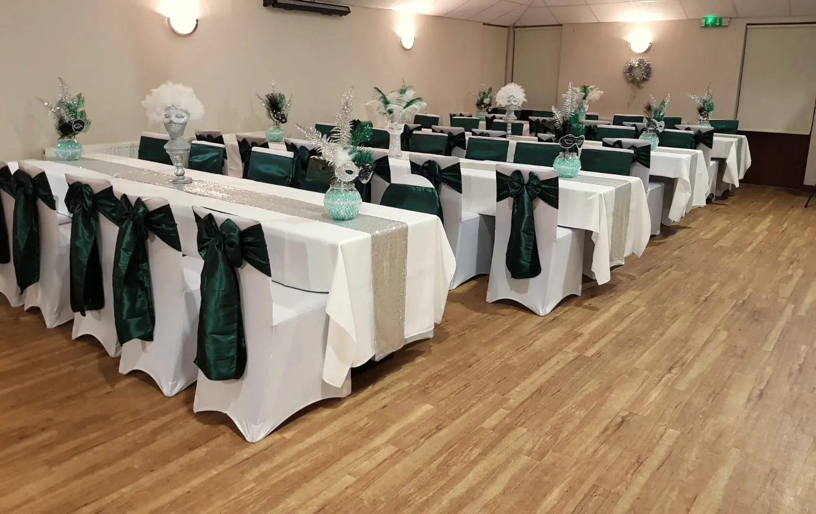 Long tables with white linen and dark green sashes