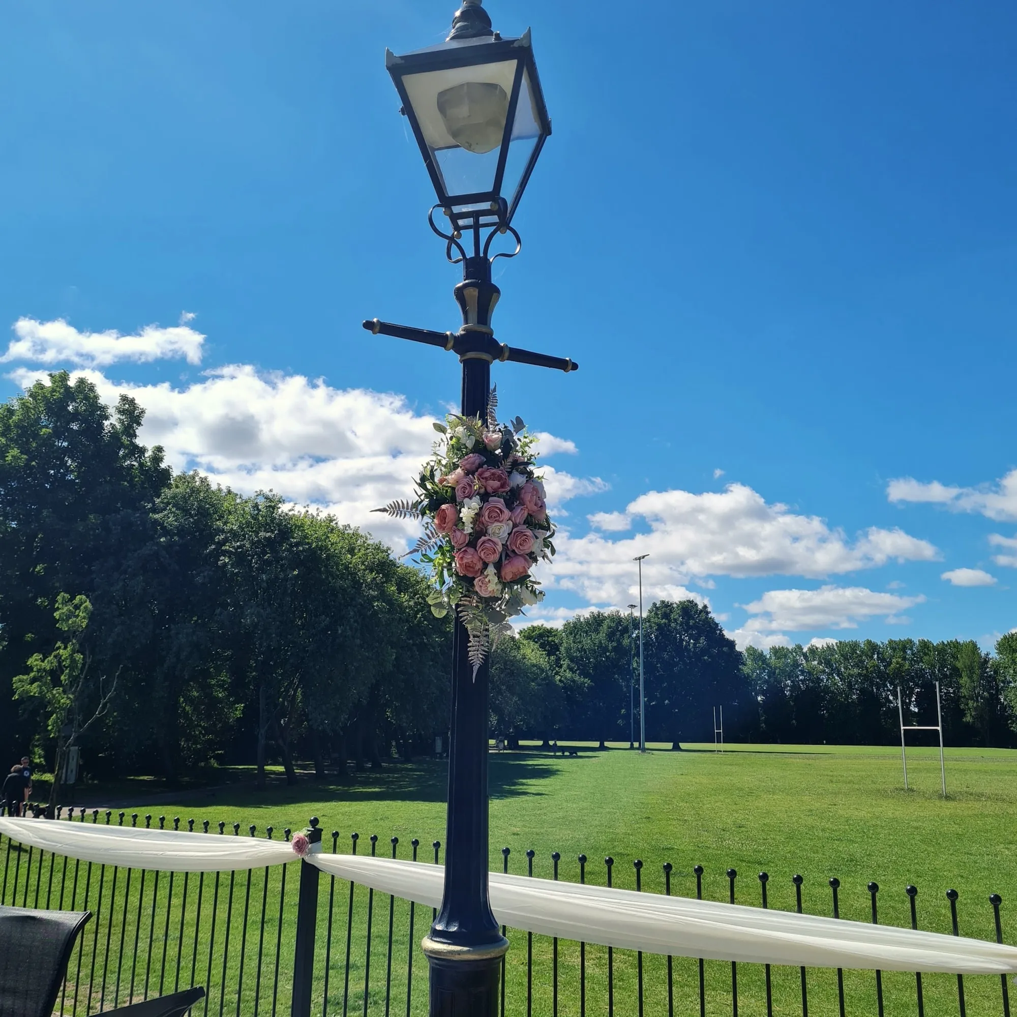 Lamp post dressed with flowers, overlooking the playing fields