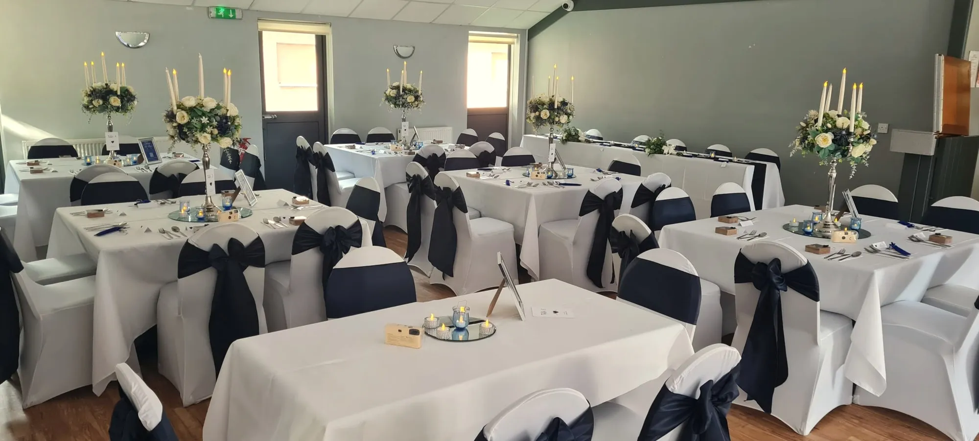 Round tables with navy sashes and candelabra centrepieces