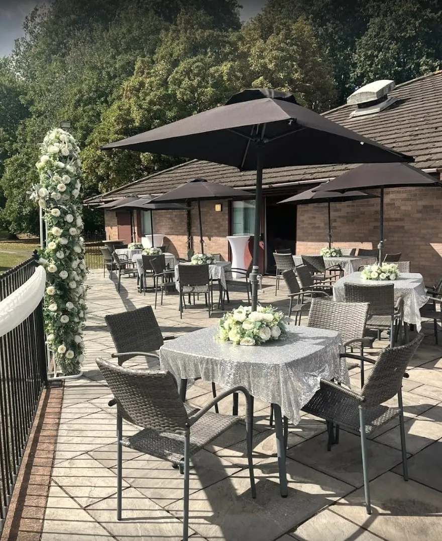 Patio seating under parasols beside a flower arch