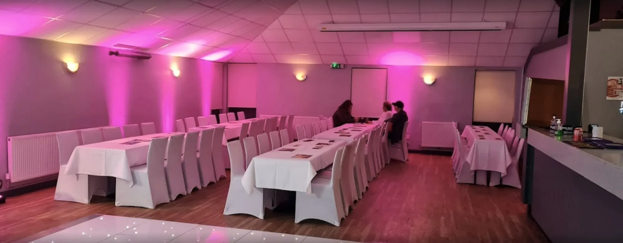 Long tables under pink uplighting