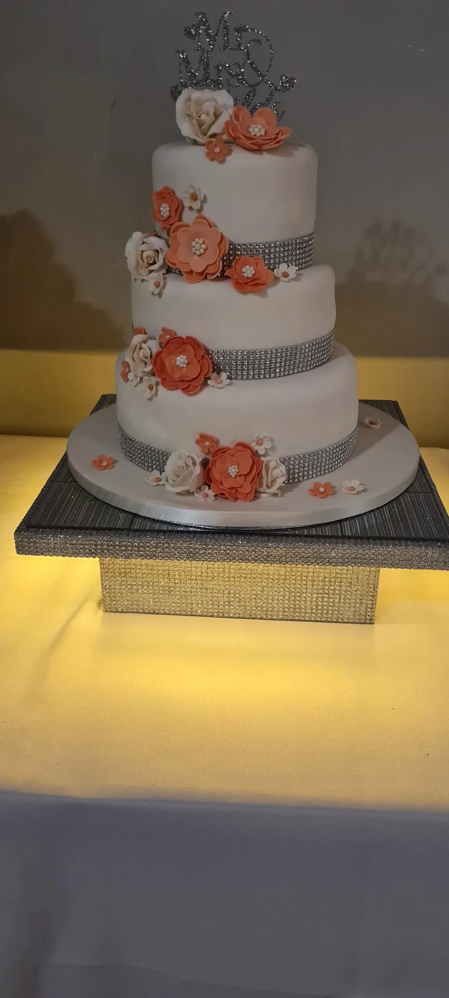 Three-tier wedding cake with coral sugar flowers